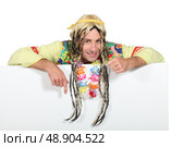 Man wearing a costume standing behind a blank sign. Стоковое фото, агентство Ingram Publishing / Фотобанк Лори