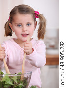 Young girl tossing a salad. Стоковое фото, агентство Ingram Publishing / Фотобанк Лори