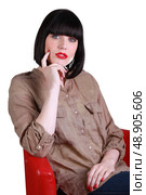 Woman sitting in a red chair. Стоковое фото, агентство Ingram Publishing / Фотобанк Лори