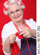 Granny with her hair in rollers and knitting. Стоковое фото, агентство Ingram Publishing / Фотобанк Лори