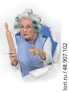 grandma with hair curlers threatening someone with rolling pin. Стоковое фото, агентство Ingram Publishing / Фотобанк Лори