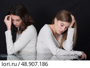 Sisters sitting back to back. Стоковое фото, агентство Ingram Publishing / Фотобанк Лори