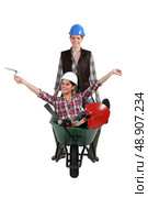 Two women messing around with wheelbarrow. Стоковое фото, агентство Ingram Publishing / Фотобанк Лори