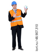Engineer holding house of money. Стоковое фото, агентство Ingram Publishing / Фотобанк Лори