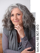 Grey-haired woman touching chin. Стоковое фото, агентство Ingram Publishing / Фотобанк Лори