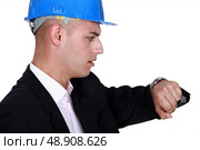 Worried engineer looking at the time. Стоковое фото, агентство Ingram Publishing / Фотобанк Лори