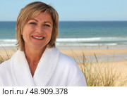 Woman with a bathrobe on the beach. Стоковое фото, агентство Ingram Publishing / Фотобанк Лори