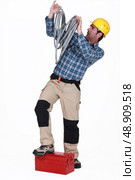 Electrician swamped with cables. Стоковое фото, агентство Ingram Publishing / Фотобанк Лори
