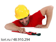 Man struggling to reach a pipe wrench. Стоковое фото, агентство Ingram Publishing / Фотобанк Лори