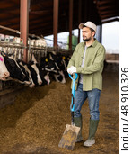 Farmer with shovel standing in cowshed. Стоковое фото, фотограф Яков Филимонов / Фотобанк Лори
