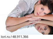 Young woman resting her head on a mirrored surface. Стоковое фото, агентство Ingram Publishing / Фотобанк Лори