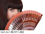 Woman holding hand fan. Стоковое фото, агентство Ingram Publishing / Фотобанк Лори