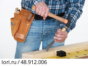 Tradesman chiseling a plank of wood. Стоковое фото, агентство Ingram Publishing / Фотобанк Лори