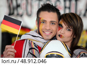 Couple supporting German football team. Стоковое фото, агентство Ingram Publishing / Фотобанк Лори