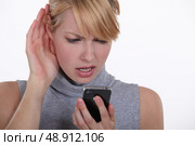Woman struggling to have a conversation on speaker phone. Стоковое фото, агентство Ingram Publishing / Фотобанк Лори