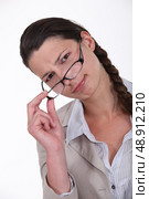 Woman peering over glasses. Стоковое фото, агентство Ingram Publishing / Фотобанк Лори