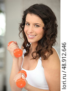 Attractive woman lifting barbells. Стоковое фото, агентство Ingram Publishing / Фотобанк Лори