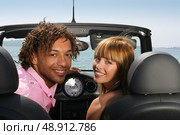 Couple sat in convertible car at the seaside. Стоковое фото, агентство Ingram Publishing / Фотобанк Лори