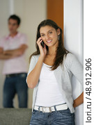 man sulking while his girlfriend is talking on the phone. Стоковое фото, агентство Ingram Publishing / Фотобанк Лори