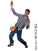 Electrician checking the voltage and getting a shock. Стоковое фото, агентство Ingram Publishing / Фотобанк Лори