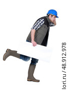 Speedy tradesman holding a blank sign. Стоковое фото, агентство Ingram Publishing / Фотобанк Лори