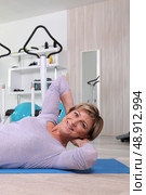 Woman doing sit-ups in a gym. Стоковое фото, агентство Ingram Publishing / Фотобанк Лори