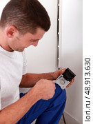 handyman looking an electrical outlet. Стоковое фото, агентство Ingram Publishing / Фотобанк Лори
