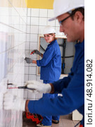 Two people tiling bathroom. Стоковое фото, агентство Ingram Publishing / Фотобанк Лори