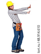 Tradeswoman pushing up against an invisible wall. Стоковое фото, агентство Ingram Publishing / Фотобанк Лори