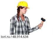 craftswoman holding a hammer looking fed up. Стоковое фото, агентство Ingram Publishing / Фотобанк Лори