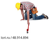 Worker reaching down. Стоковое фото, агентство Ingram Publishing / Фотобанк Лори