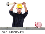 A construction worker about to open a piggy bank with a sledgehammer. Стоковое фото, агентство Ingram Publishing / Фотобанк Лори