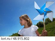 Little girl stood in filed with toy windmill. Стоковое фото, агентство Ingram Publishing / Фотобанк Лори