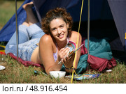 Woman laying by her tent reading. Стоковое фото, агентство Ingram Publishing / Фотобанк Лори
