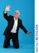 Senior man pushing invisible object. Стоковое фото, агентство Ingram Publishing / Фотобанк Лори