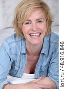 Laughing woman lying on a bed. Стоковое фото, агентство Ingram Publishing / Фотобанк Лори