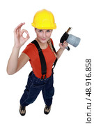 Tradeswoman holding a blowtorch and giving the a-ok sign. Стоковое фото, агентство Ingram Publishing / Фотобанк Лори