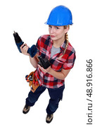 Tradeswoman holding a battery-powered power tool. Стоковое фото, агентство Ingram Publishing / Фотобанк Лори