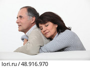 Couple hugging on their couch. Стоковое фото, агентство Ingram Publishing / Фотобанк Лори