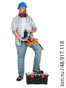 Tradesman blowing on his screwdriver. Стоковое фото, агентство Ingram Publishing / Фотобанк Лори