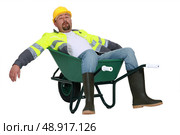 Exhausted builder laying in wheelbarrow. Стоковое фото, агентство Ingram Publishing / Фотобанк Лори