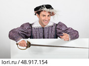 Man in fancy dress stood with blank advertising board. Стоковое фото, агентство Ingram Publishing / Фотобанк Лори