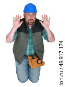 Builder on his knees pleading. Стоковое фото, агентство Ingram Publishing / Фотобанк Лори