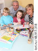 Couple drawing with their grandchildren. Стоковое фото, агентство Ingram Publishing / Фотобанк Лори