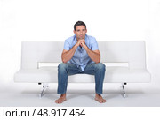beautiful young man sitting on the sofa. Стоковое фото, агентство Ingram Publishing / Фотобанк Лори