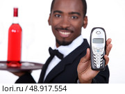 Restaurant waiter holding telephone. Стоковое фото, агентство Ingram Publishing / Фотобанк Лори
