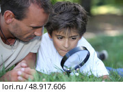 father and kid with magnifying glass. Стоковое фото, агентство Ingram Publishing / Фотобанк Лори