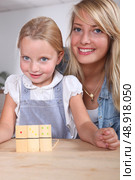 Woman and child playing dominoes. Стоковое фото, агентство Ingram Publishing / Фотобанк Лори