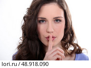 Woman with finger over mouth. Стоковое фото, агентство Ingram Publishing / Фотобанк Лори