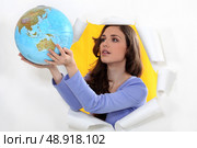 Woman getting out of hole with globe. Стоковое фото, агентство Ingram Publishing / Фотобанк Лори